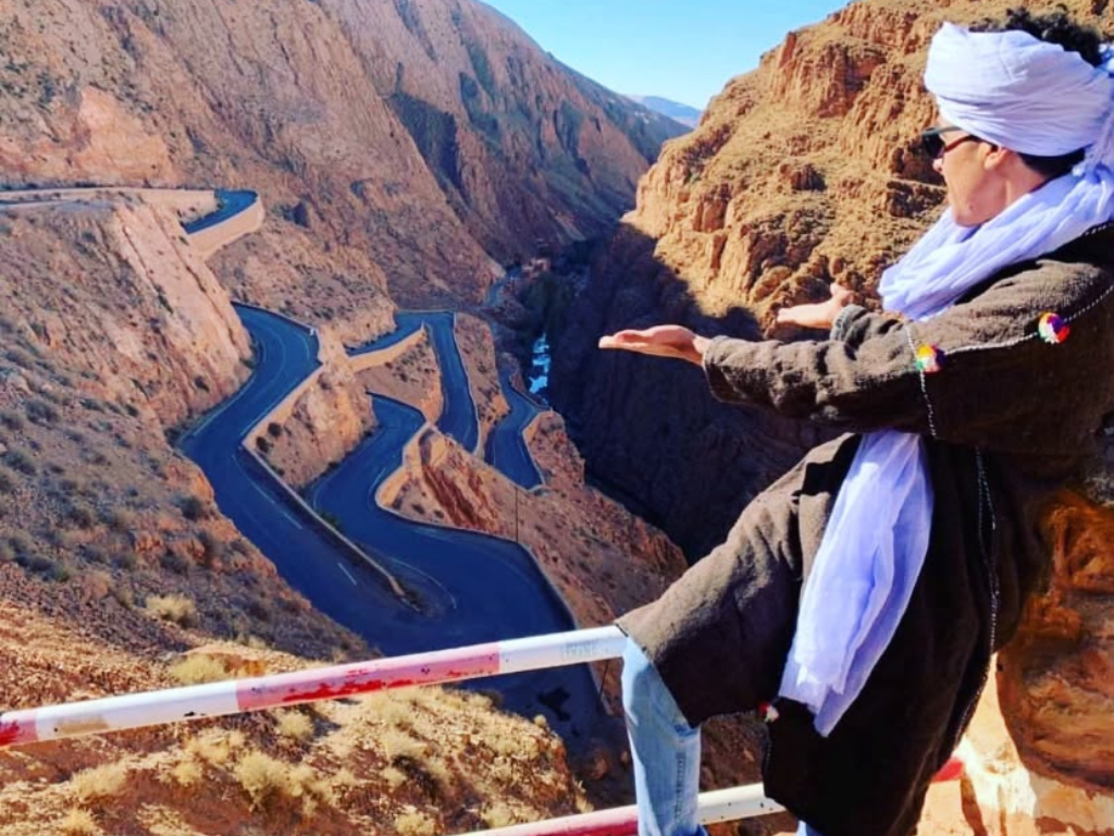 Guide overlooking the switchback mountain road through the Dades Valley on the route from Marrakech to Merzouga